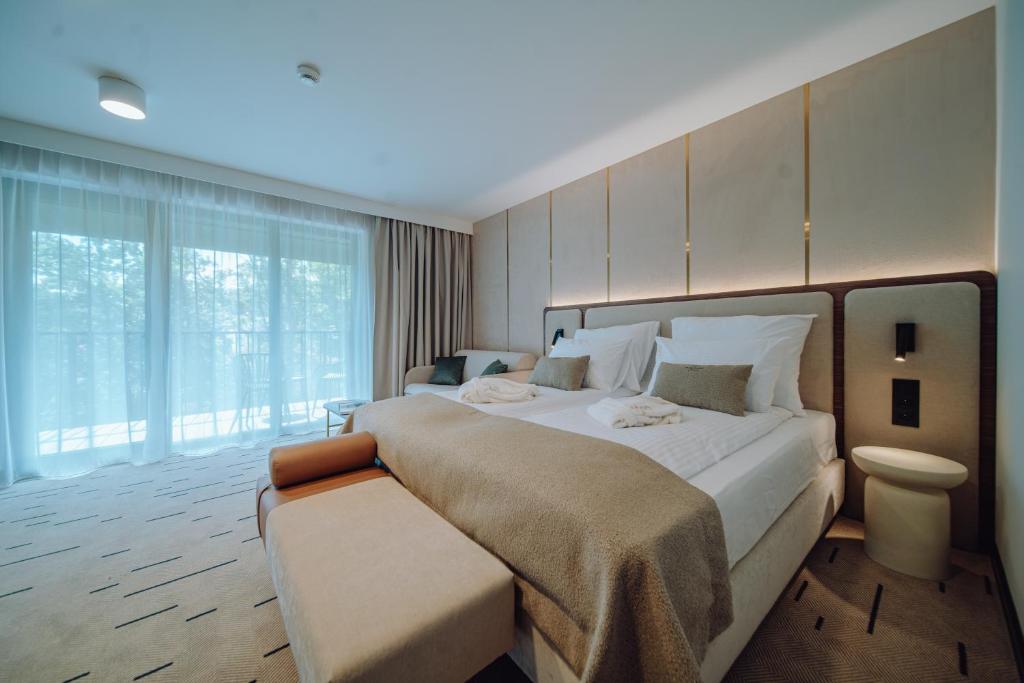 a bedroom with a large bed and a large window at Mariental Hotel & SPA in Szklarska Poręba