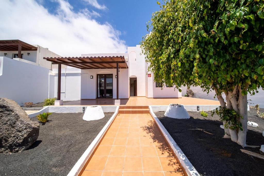 a white house with a tree in front of it at Villa Turquesa in Playa Blanca