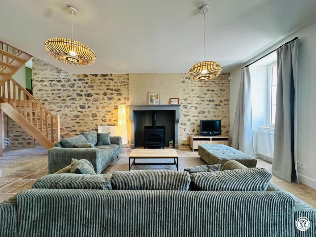 a living room with two couches and a fireplace at La Ferme de Sainte Isabelle in Montlay-en-Auxois
