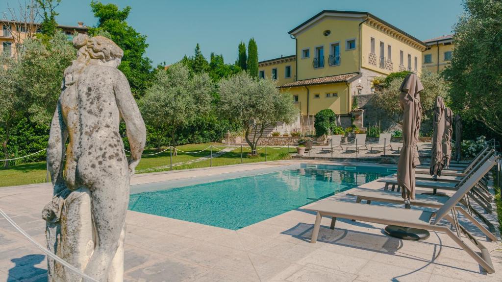 a statue of a woman standing next to a swimming pool at Corte Pulchra - Italian Homing in Pozzolengo