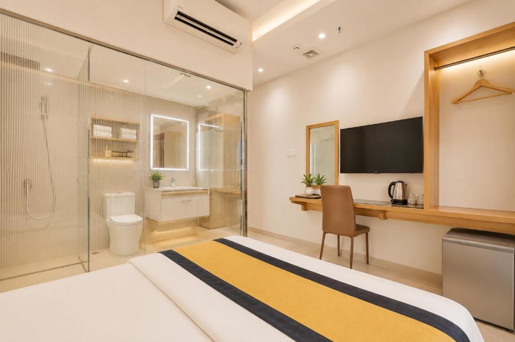 a hotel room with a bed and a desk and a television at Son Mi Hotel in Ho Chi Minh City
