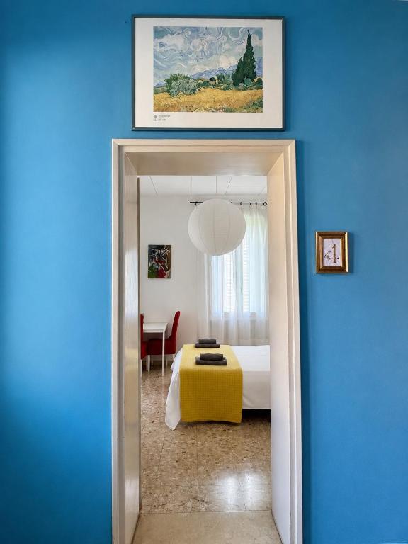 a blue room with a bedroom with a bed and a table at Giove Rooms in Verona