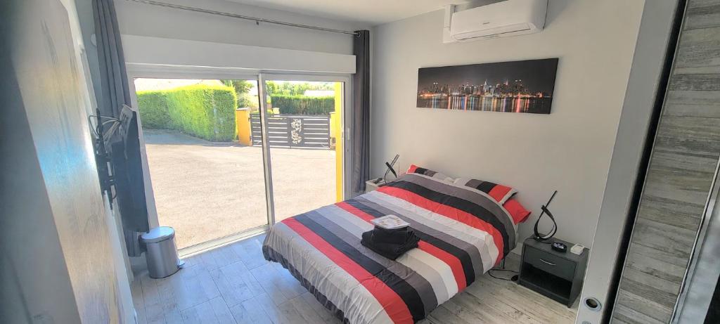 a bedroom with a bed and a sliding glass door at Chez Manon et Stéphane in Prissé