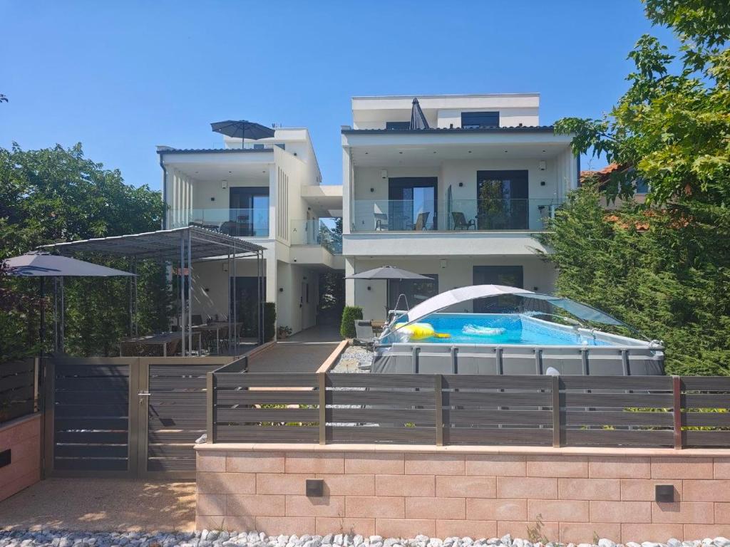 a large house with a swimming pool in front of it at Mulberry Suites in Paralia Dionysiou