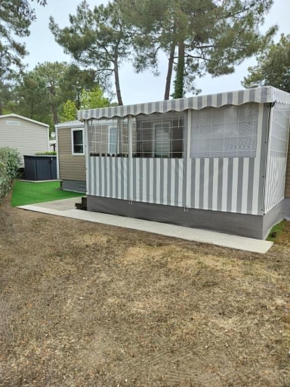a tiny house with a porch in a yard at Bienvenue chez Diamina et Patrick in La Tremblade