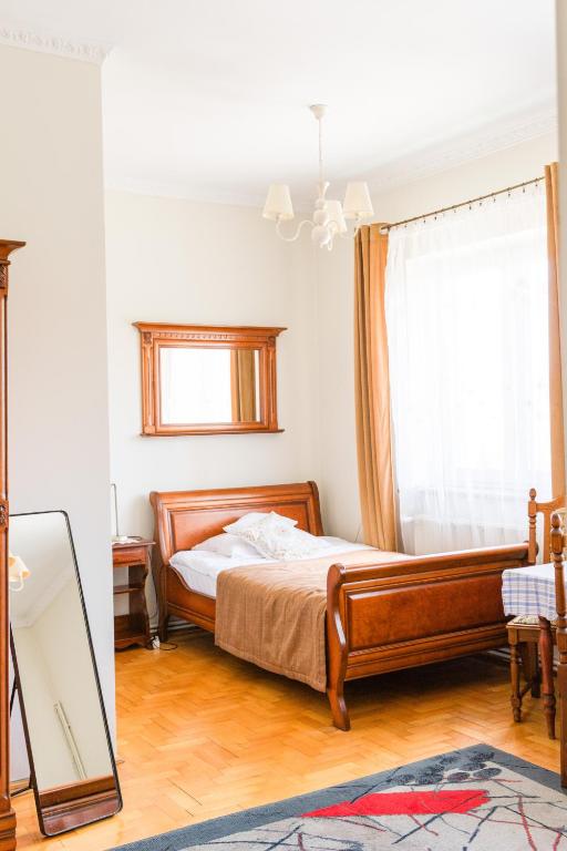 a bedroom with a bed with a mirror and a window at Rezydencja Jagiellońska in Sanok