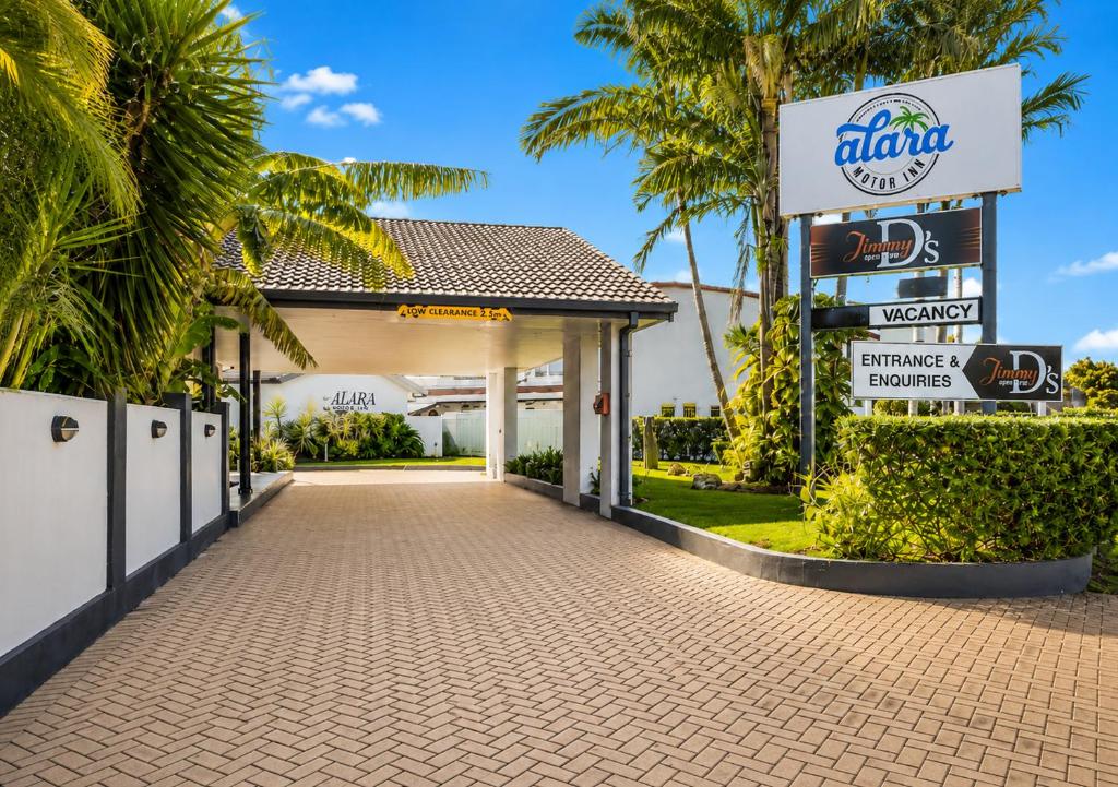 a entrance to a mobil gas station with palm trees at Alara Motor Inn in Mackay