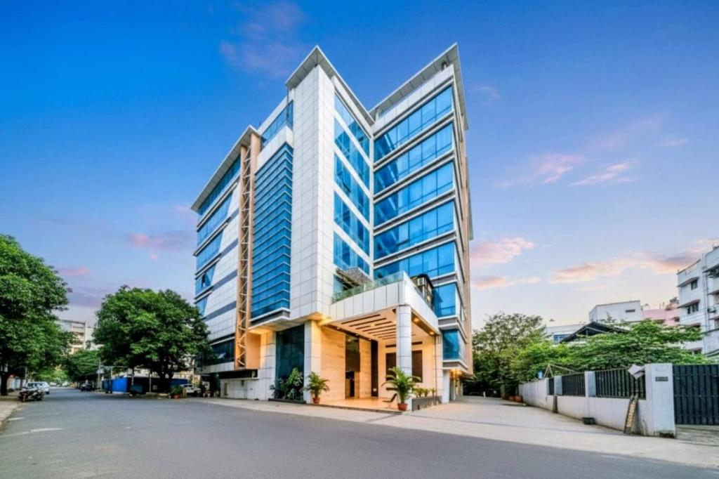 a tall building on a street with a blue sky at Hotel Annex International Near International Airport in Mumbai