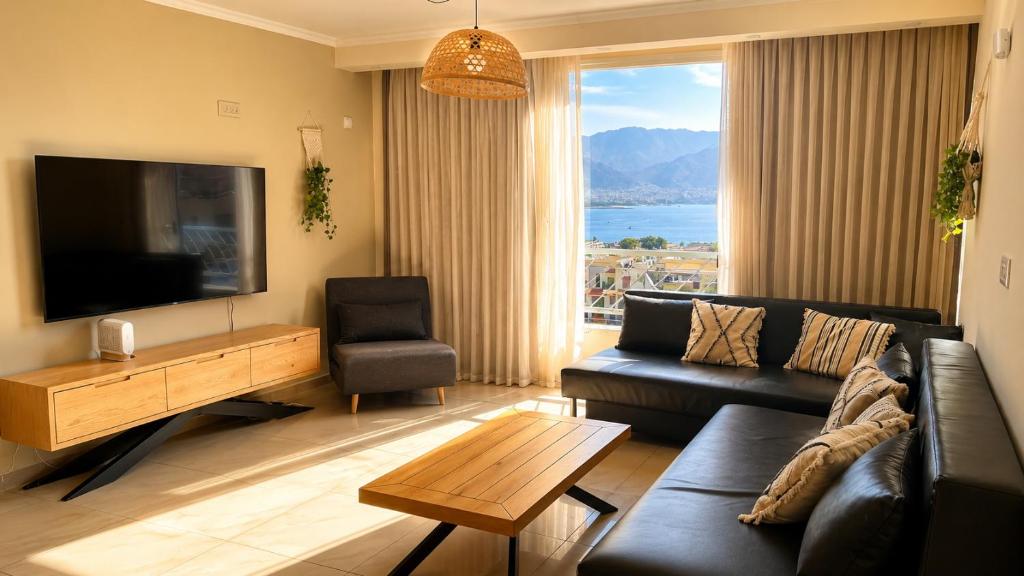 a living room with a couch and a flat screen tv at Milano Suite in Lev Eilat in Eilat