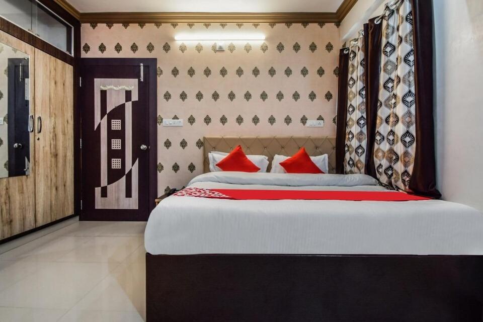 a bedroom with a large bed with red pillows at Hotel Amrapali UDAIPUR BEST GORUP BOOKING HOTEL NEAR CA CIRCLE in Udaipur