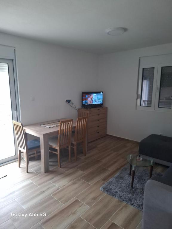 a living room with a table and chairs and a television at Nido Apartman in Kotor