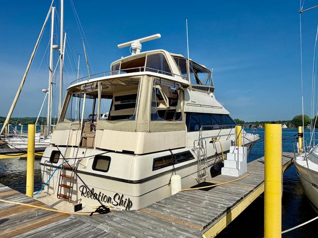 a white boat is docked at a dock at Relation Ship in Onekama