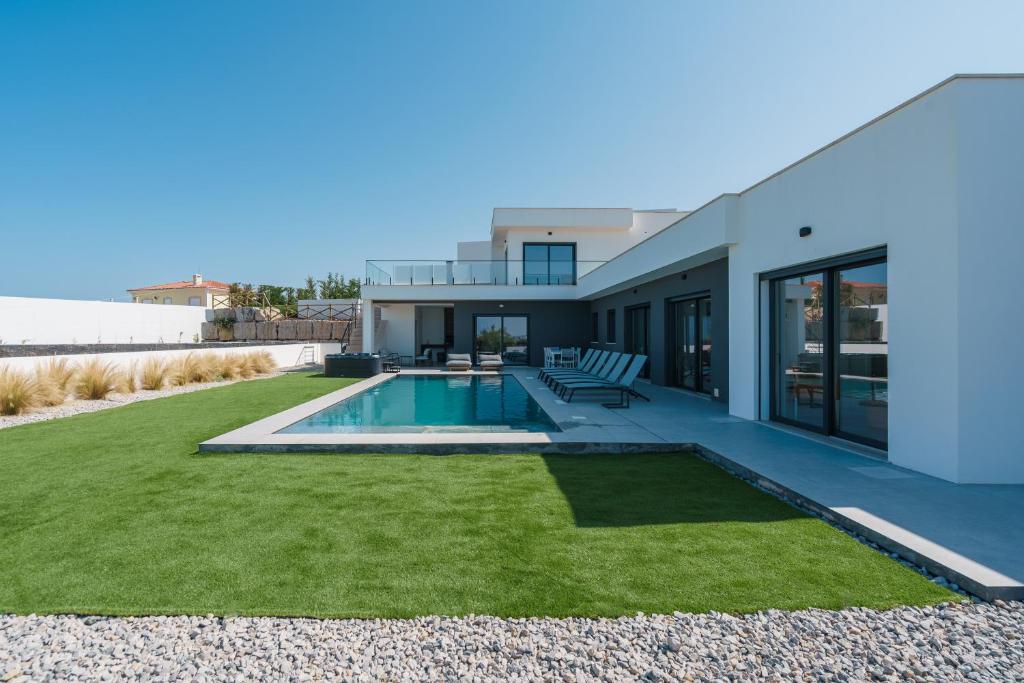 a house with a backyard with a swimming pool at Villa Locki with jacuzzi, private pool and sea view in Lourinhã