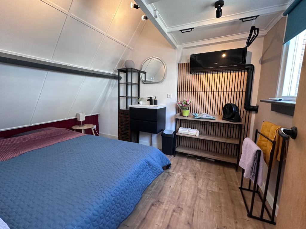 a bedroom with a blue bed and a sink at Barefoot Cottage in Noordwijk