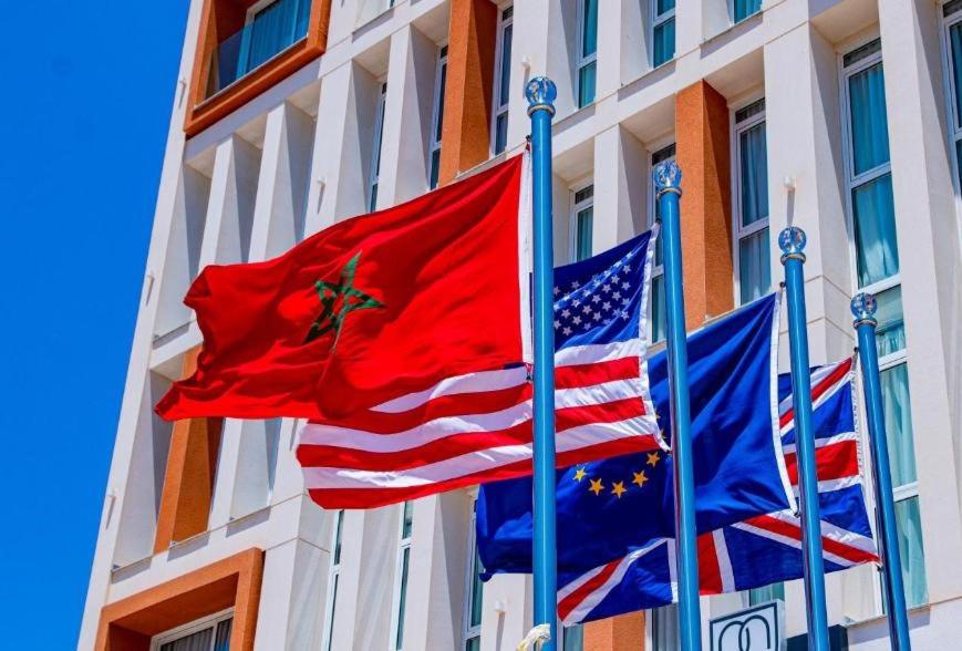 three flags flying in front of a building at Marchica Hotel in Nador