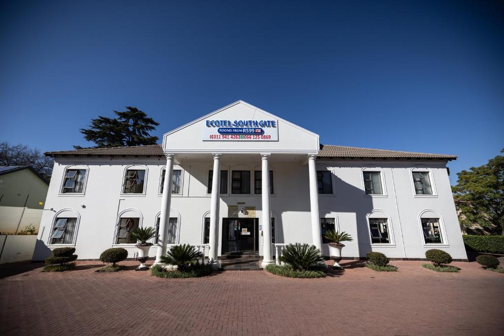 a white building with a sign on the front of it at Ecotel Southgate in Southgate