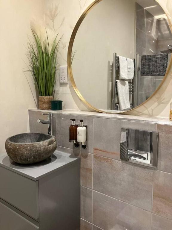 a bathroom with a stone sink and a mirror at Little Apple Cottage- Free Parking, Hot tub, Fire, Town Centre in Appleby