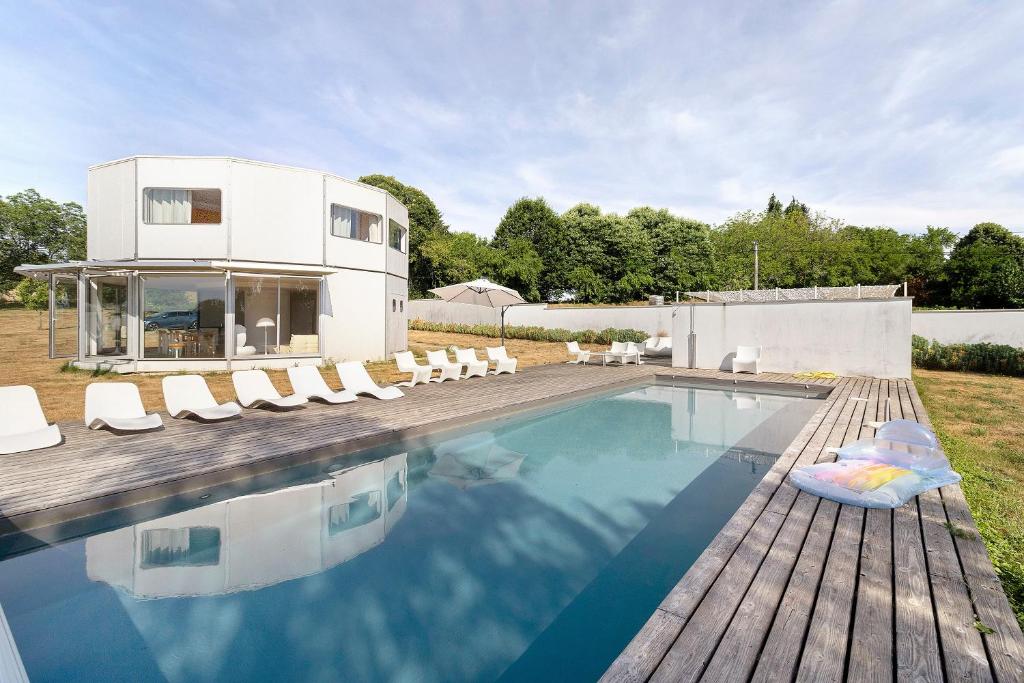 a house with a swimming pool and lounge chairs at Gite Design La Station in Angoisse