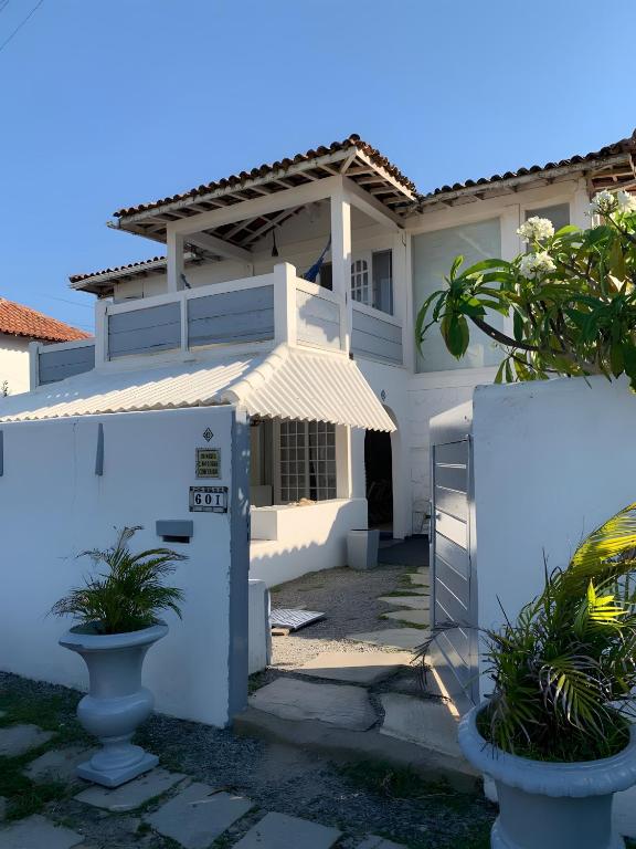 a white house with a gate in front of it at White House Canto in Búzios