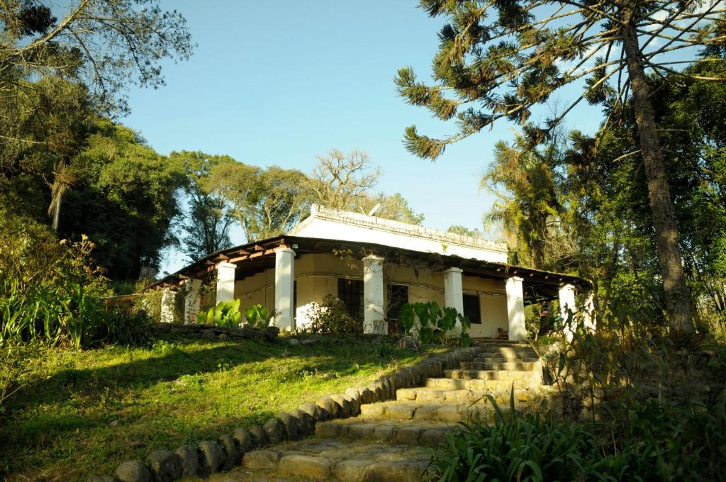 a white house with a stone path leading to it at Finca La Colorada in San Salvador de Jujuy