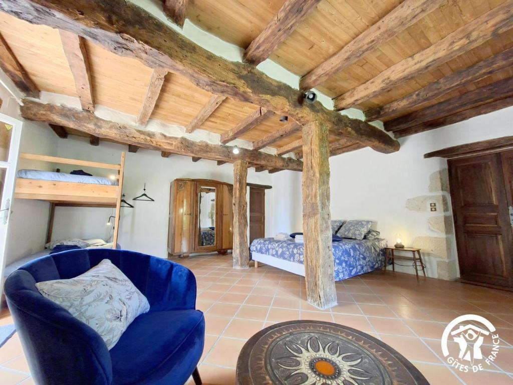 a bedroom in a house with a bed and a chair at Brasserie du Goutté in Roquefort