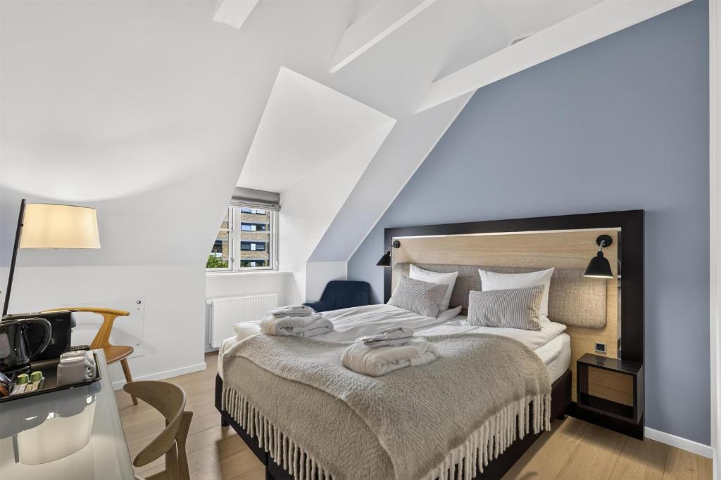 a bedroom with a bed with towels on it at Gentofte Hotel in Gentofte