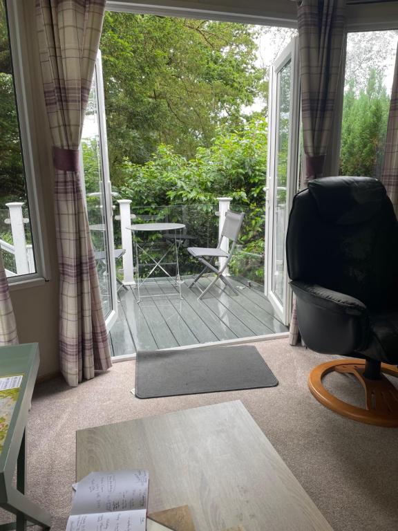 a living room with a balcony with a chair and a table at Beauport Retreat in Hastings