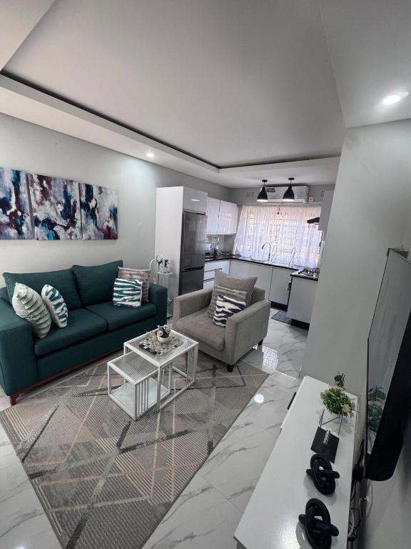 a living room with a couch and a table at MAITA Apartments - Silverest, Lusaka in Chongwe