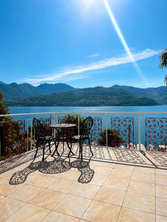 a table and chairs on a balcony overlooking a lake at BaB Apartments Tavernola in Tavernola Bergamasca