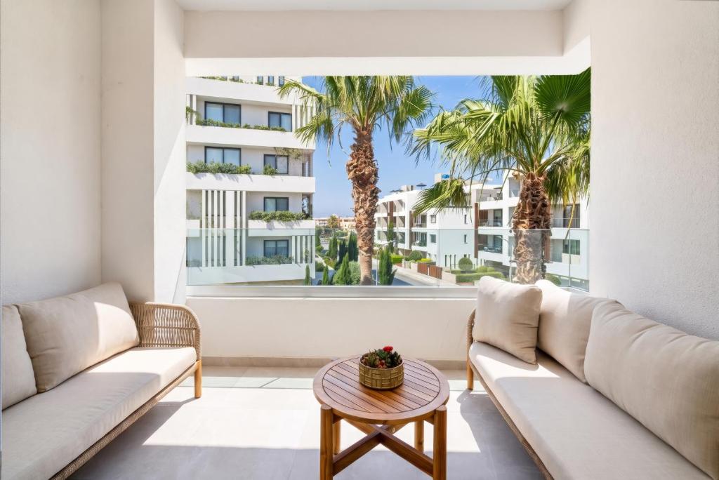 a living room with two couches and a table at Avenue by Deserve in Paphos