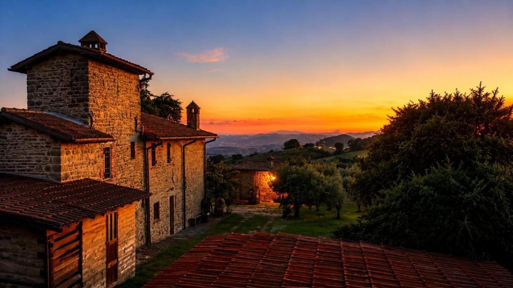 an image of a sunset behind an old building at Nerbone Farm Retreat in Perugia