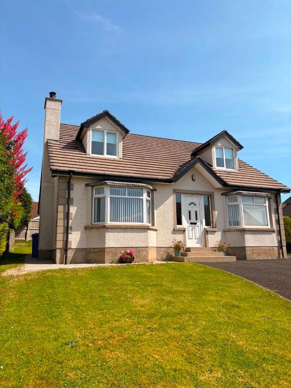 a house with a grassy yard in front of it at Moyle Manor in Ballycastle