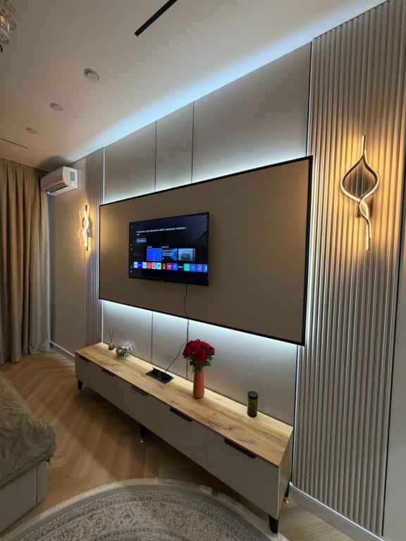 a living room with a flat screen tv on a wall at Жк Prime Park 2 in Shymkent