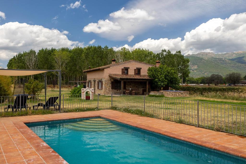 a swimming pool in front of a house at Paraje Navazos in Gavilanes