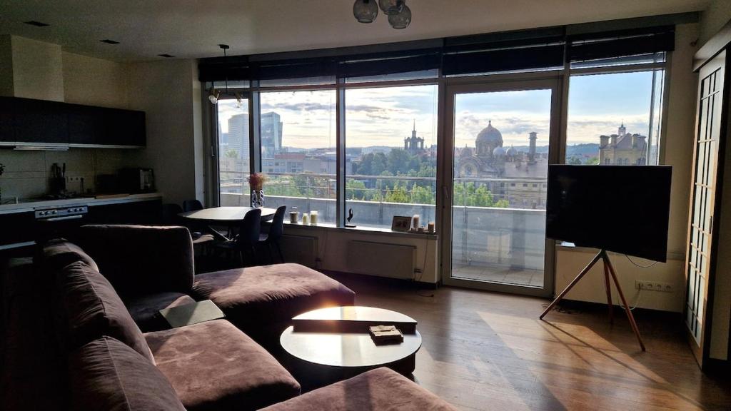 a living room with a couch and a flat screen tv at Modern skyline-view condo at a luxury complex in Vilnius