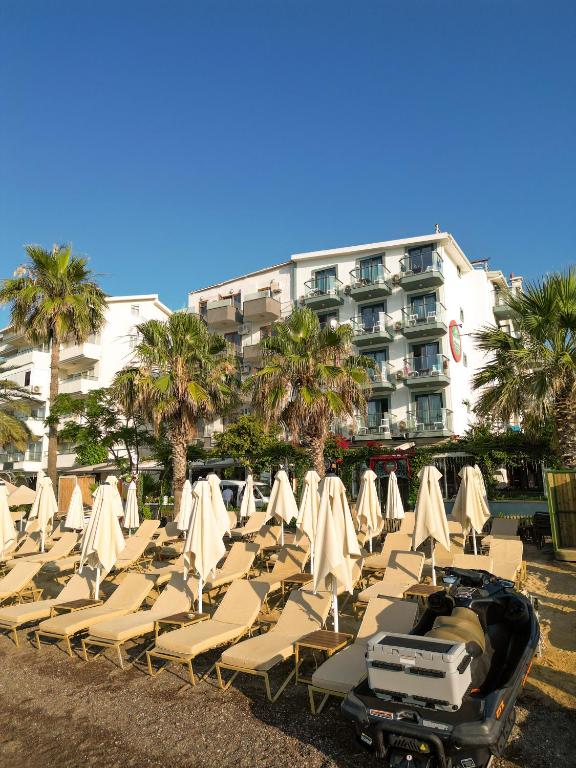 a row of beach chairs and umbrellas in front of a building at Yeshill Boutique Hotel in Marmaris