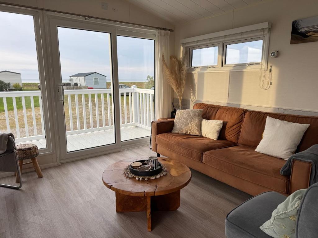 a living room with a couch and a table at Camping Zeezicht - Chalet 16 in Westerland