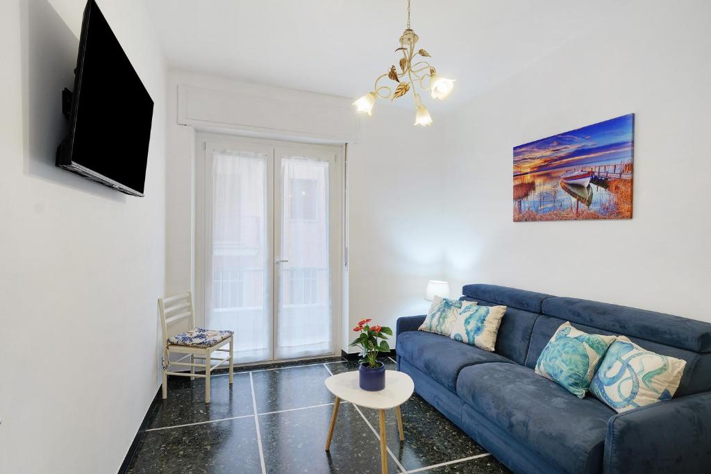 a living room with a blue couch and a tv at Casa Antonio in Alassio