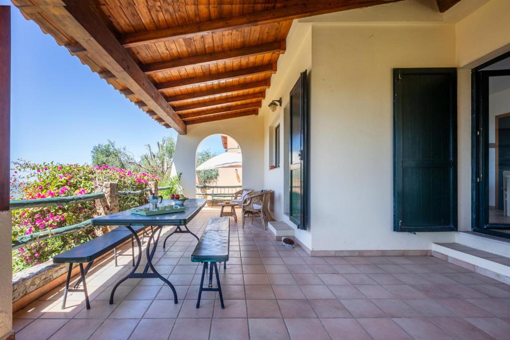 a patio with a table and chairs on a balcony at Il Fortino Sea View in Geremèas