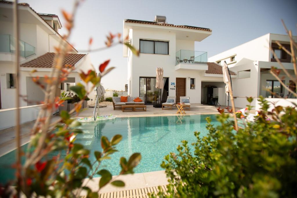 a villa with a swimming pool in front of a house at Villa Kokona Private Pool Sea View in Sophtadhes