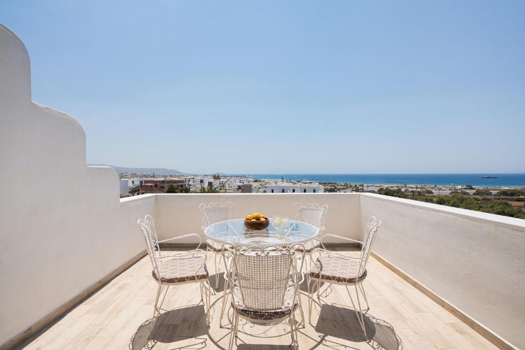 a table and chairs on a balcony with the ocean at Passa Corda Villa in Agios Prokopios