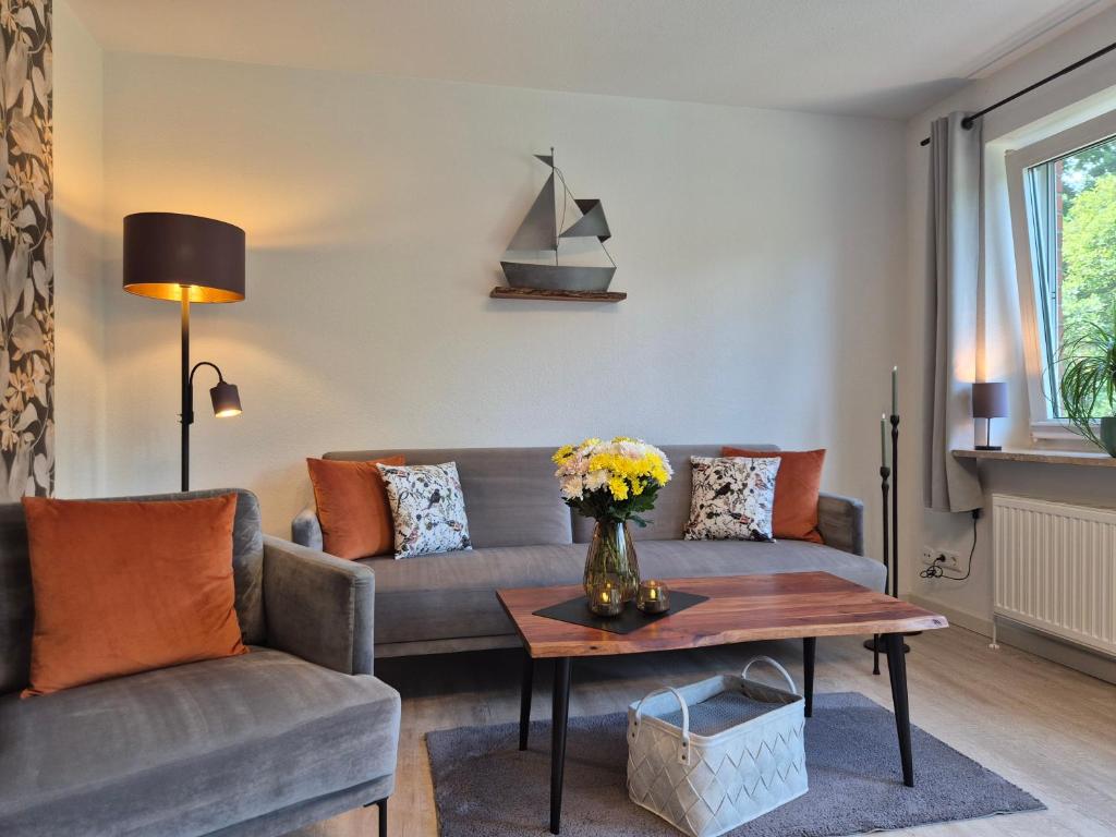 a living room with a couch and a table at Vogelkoje - Urlaub an der Nordsee in Nordfriesland in Bredstedt
