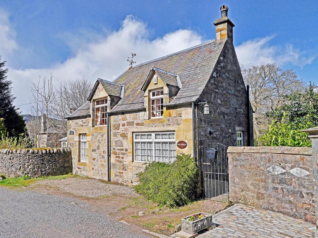 an old stone house with a black roof at The Coach House in Birnam