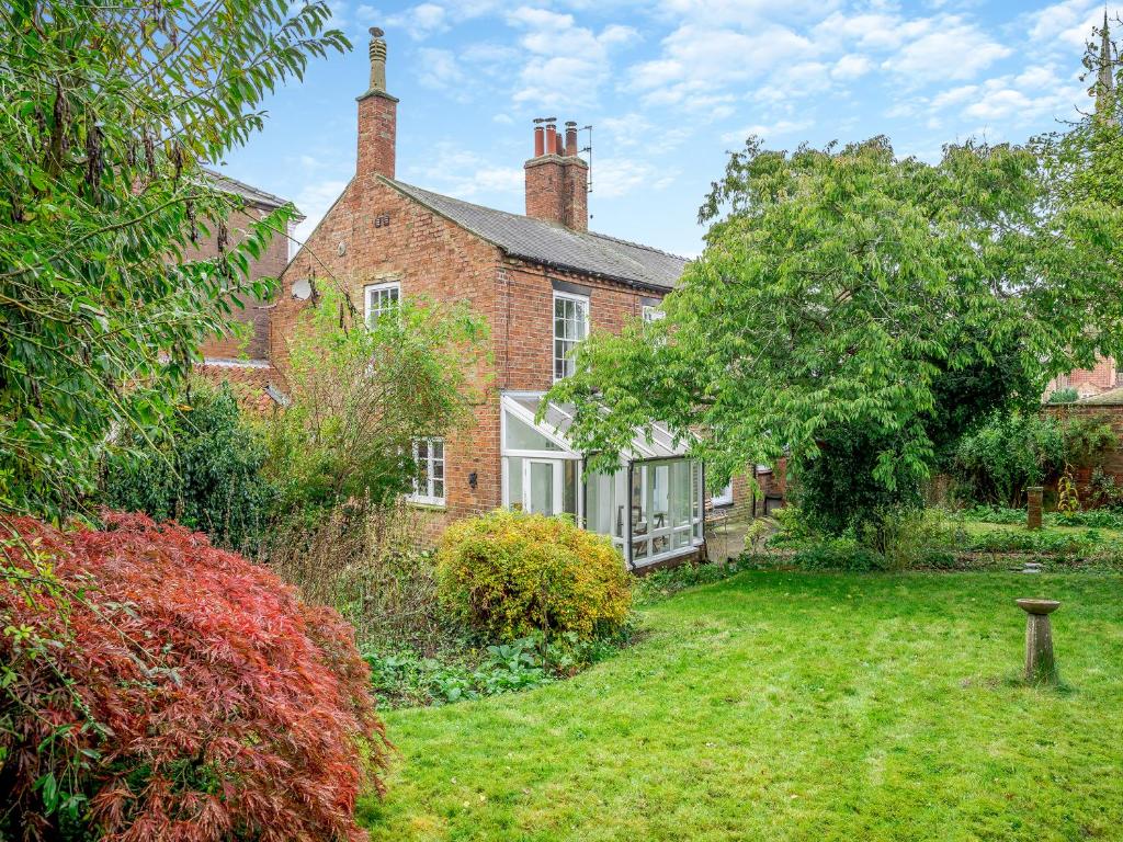 an exterior view of a brick house with a yard at Misdale House in Louth