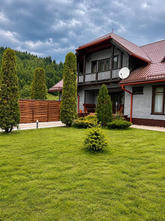 a house with a yard with a fence and trees at Spring Apartments in Gheorgheni