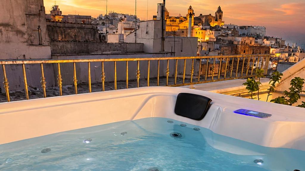 a bath tub on a balcony with a view of a city at 21mq Suite Jacuzzi in Ostuni