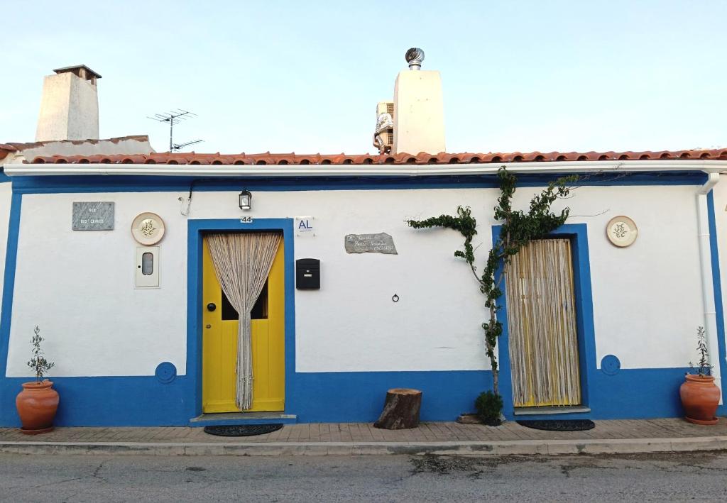 a blue and white house with a yellow door at Casinha das Portas Amarelas in Monsaraz