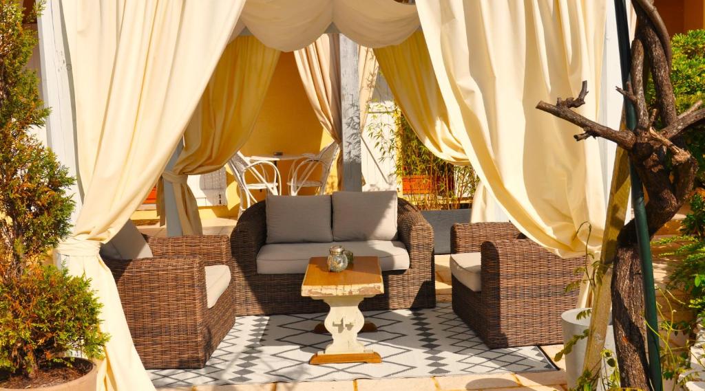 a patio with wicker chairs and a table at Ô Reflet du Lac in Groléjac