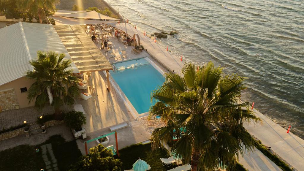 Eine Draufsicht auf ein Schwimmbecken neben dem Meer in der Unterkunft Agoulos Beach Hotel in Argassi