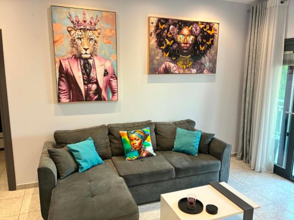 a living room with a couch and two paintings on the wall at Annaria in Leptokarya